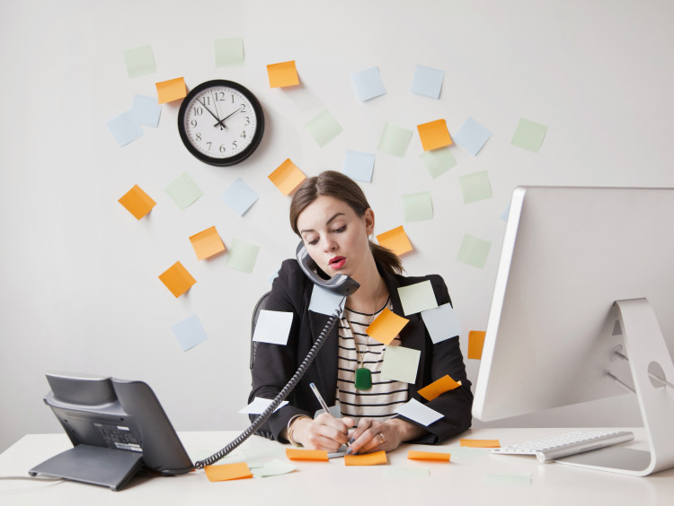 Woman working on the computer and talking on the phone