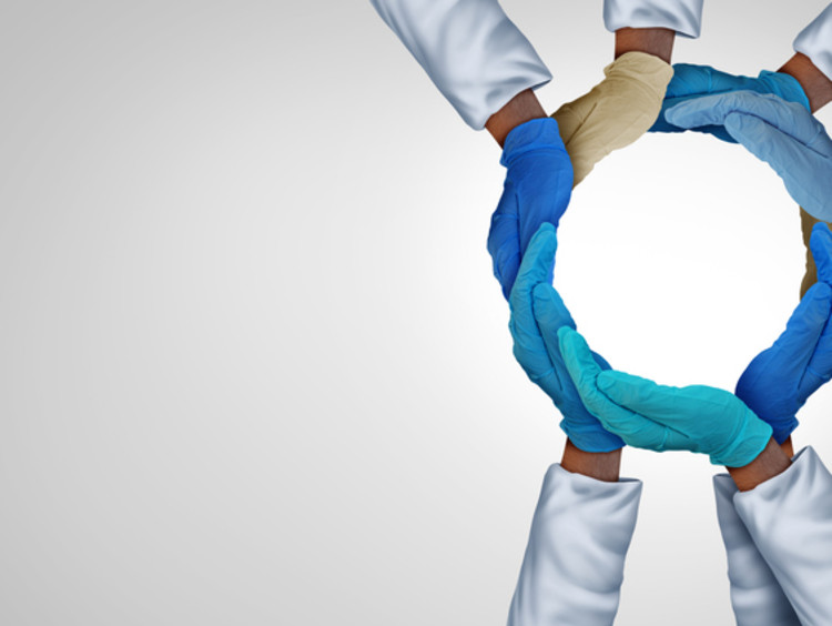 Doctors and nurses forming hands together in circle