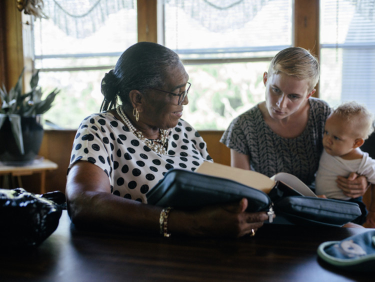 Two women and a baby reading the Bible