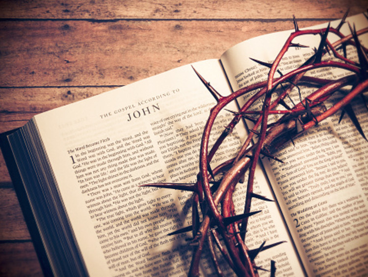 Gospel of John open with crown of thorns on top of it