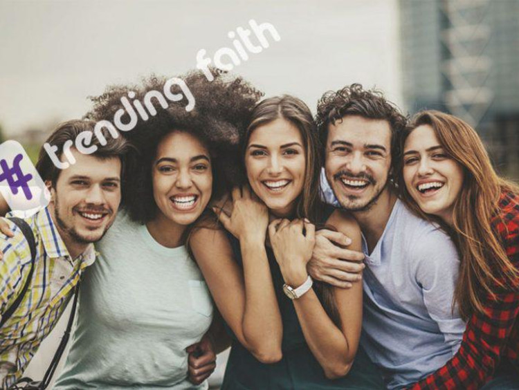 Diverse group of young adults huddle together for a photo