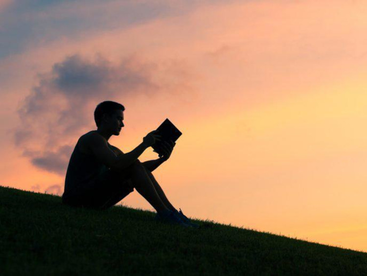 person reading at sunset