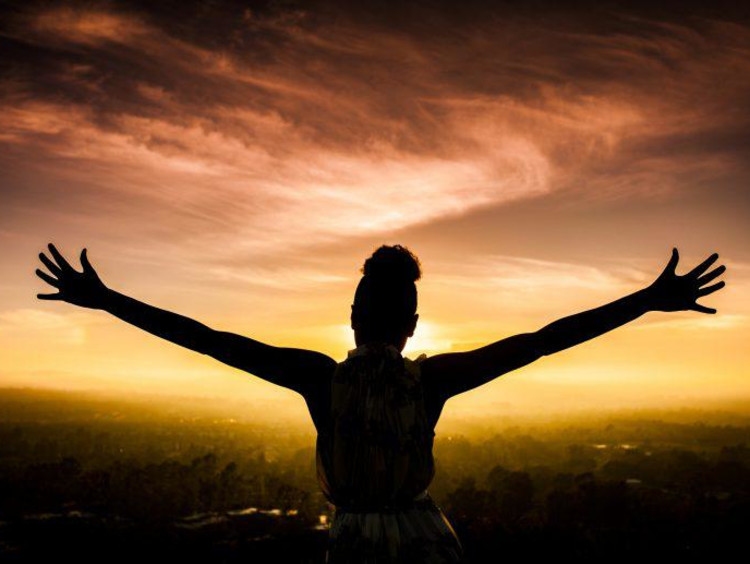Woman spreading her arms to the sky