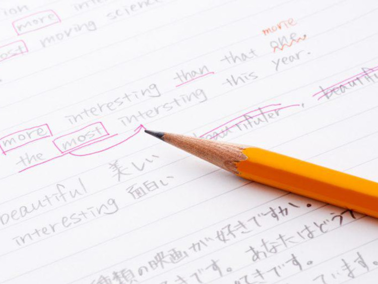 Pencil sits on top of ESL writing assignment with edits