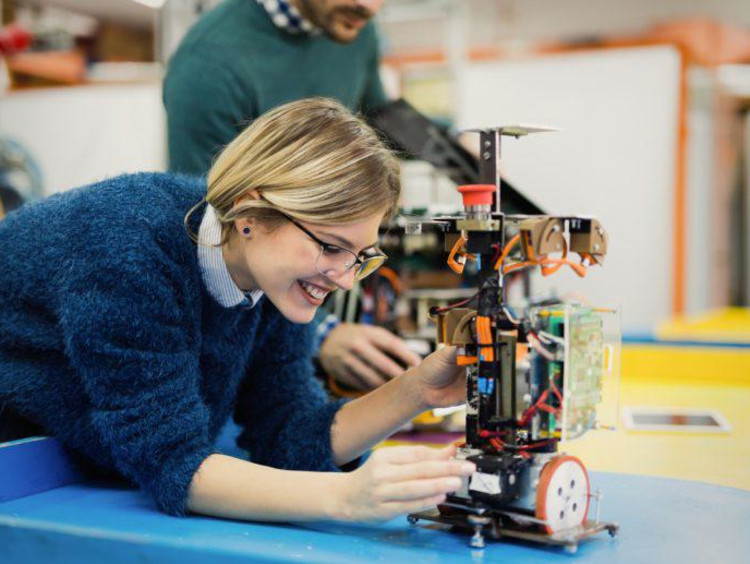 A woman working with a robot