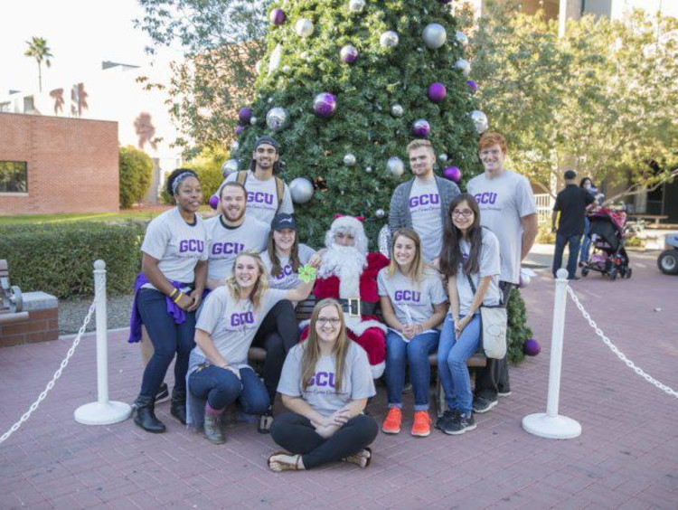 GCU students in front of a Christmas tree on campus