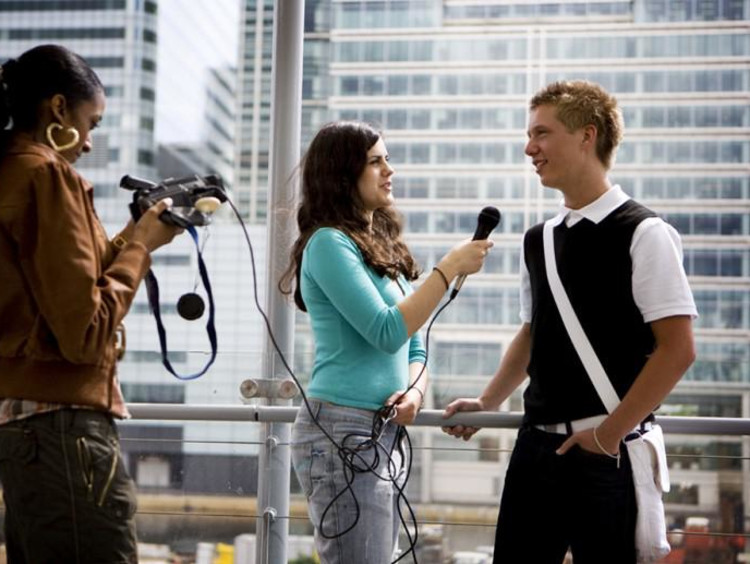 a girl interviewing a guy with camera and mic