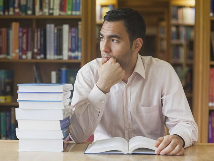 man thinking while reading a book