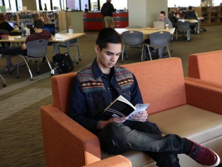 A GCU student reading in the library