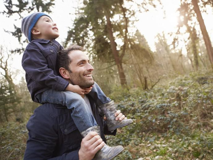 dad carrying son on his shoulders