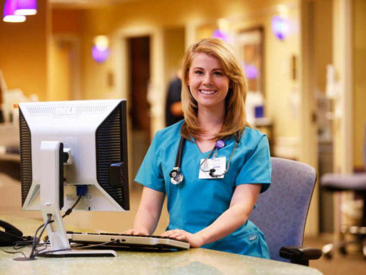 Nurse in scrubs at computer