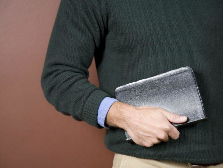 close up of man holding his Bible