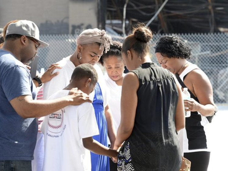 people standing in a circle and praying