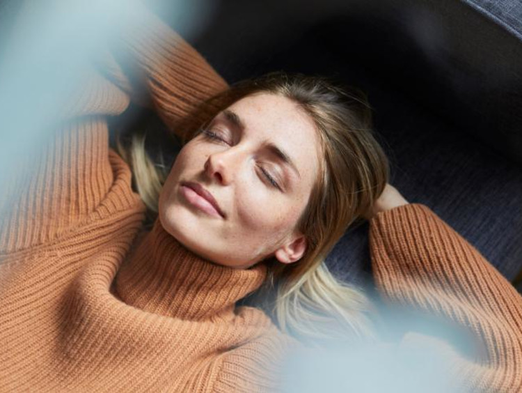 Woman contentedly smiling with eyes closed