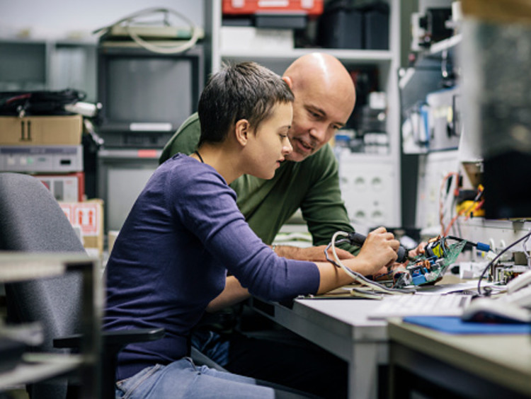 Student working with teacher on engineering degree project