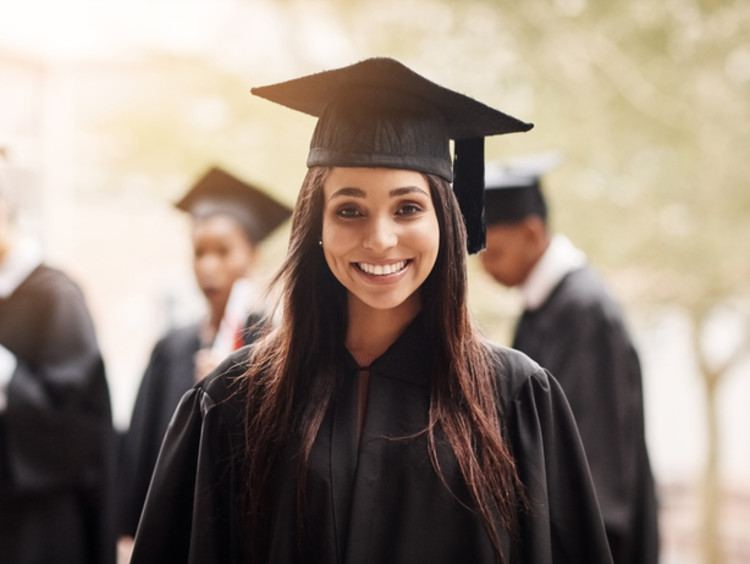 Woman smiles after her graduation ceremony