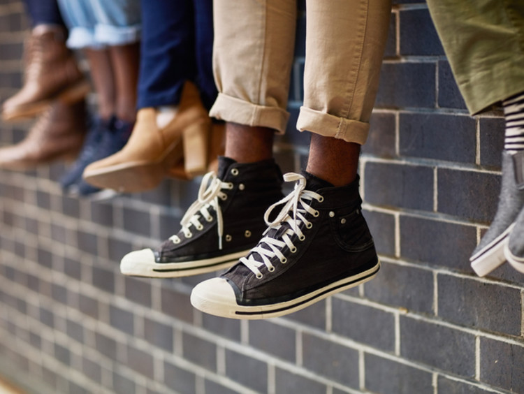 Picture of shoes of students sitting on a wall making friends