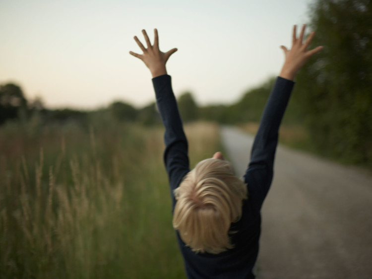Young man throws his hands towards the Heavens