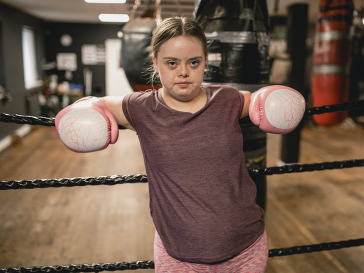 Young female boxer against the ropes fighting the good fight of faith
