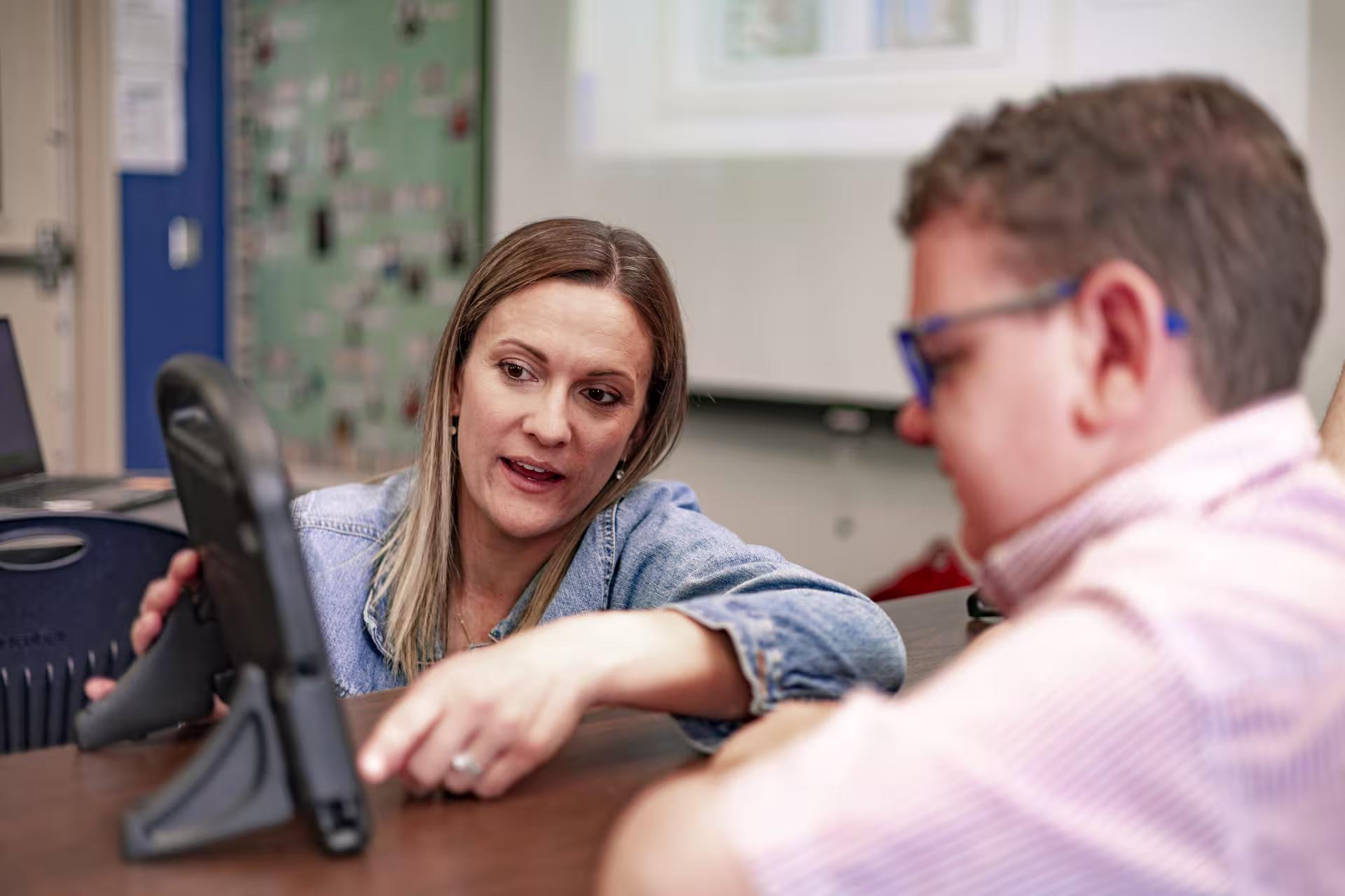 STEM education teacher using tablet talking with student