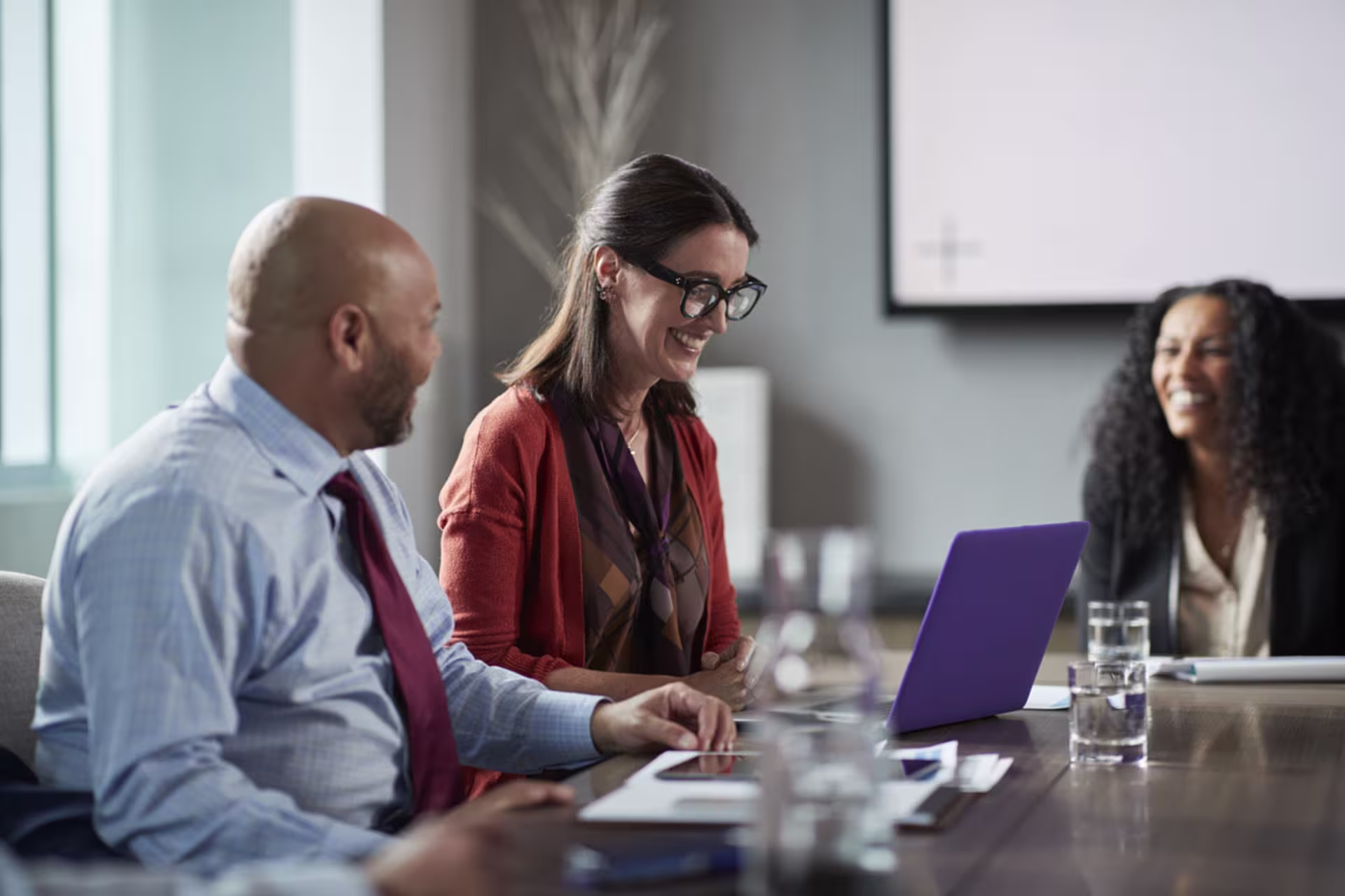 Focused shot of female Business Analytics professional conversing with male and female colleagues