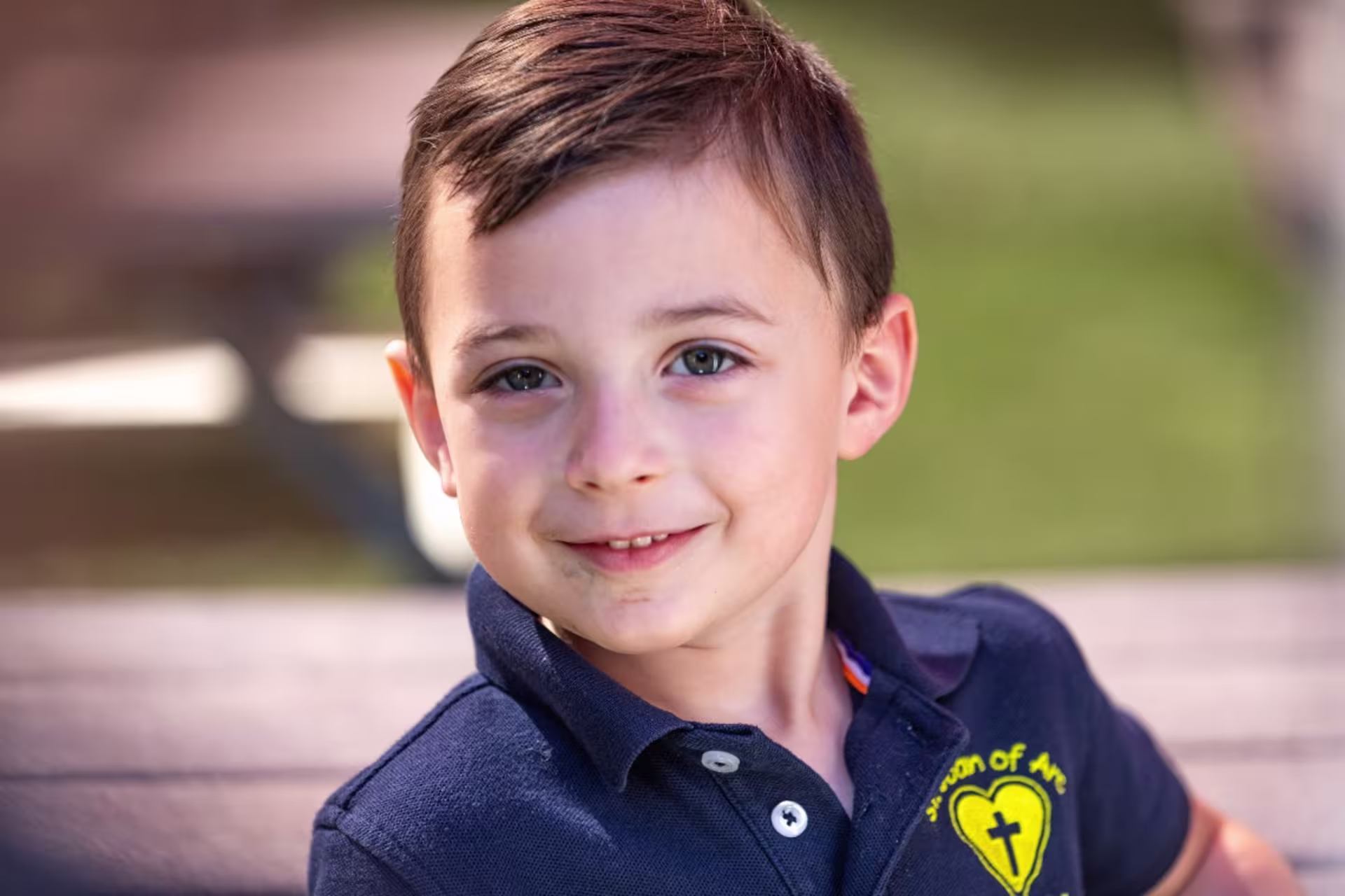 Close up of young elementary student smiling outside in school uniform