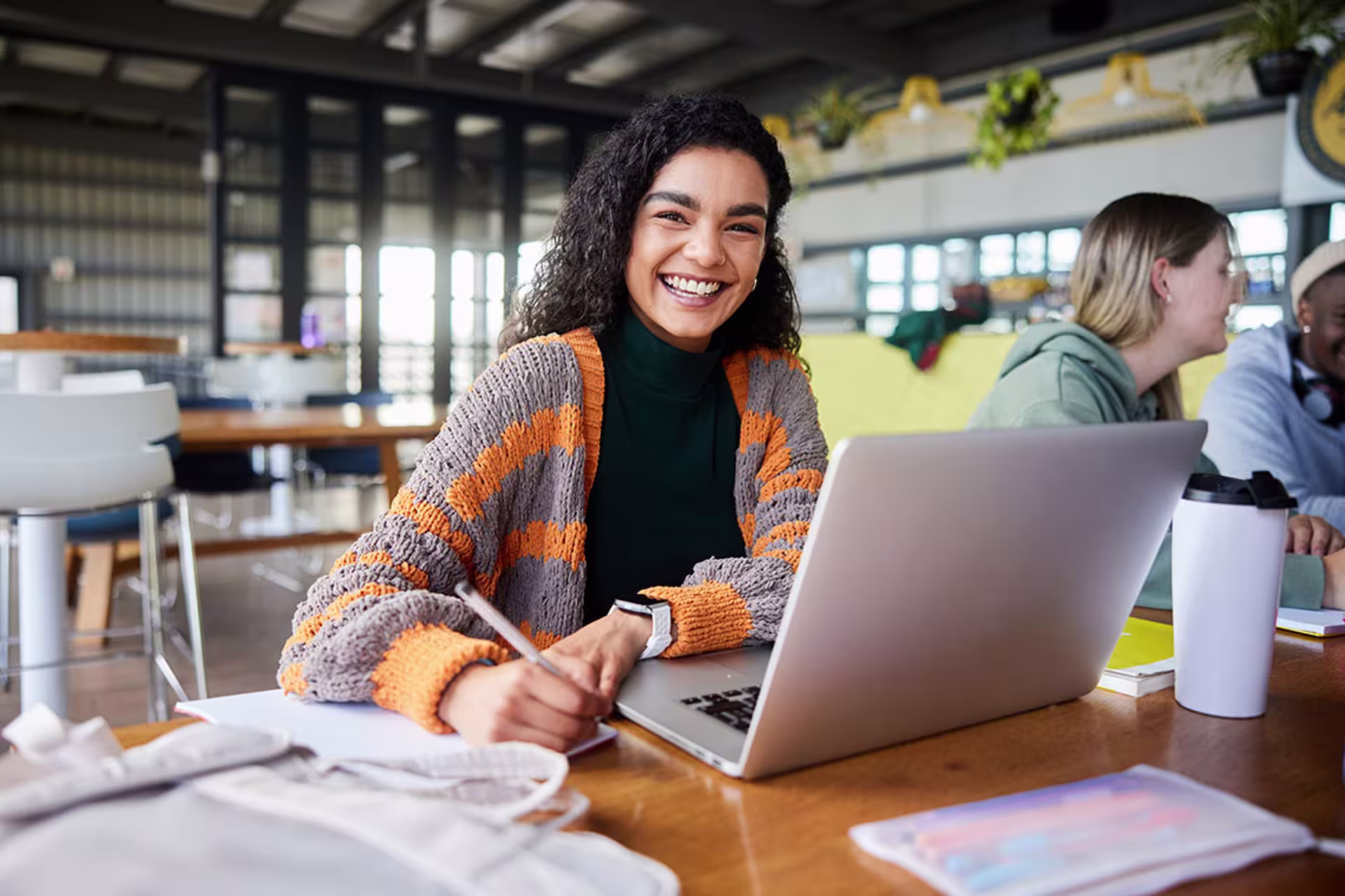 Female professional writer working on laptop in café