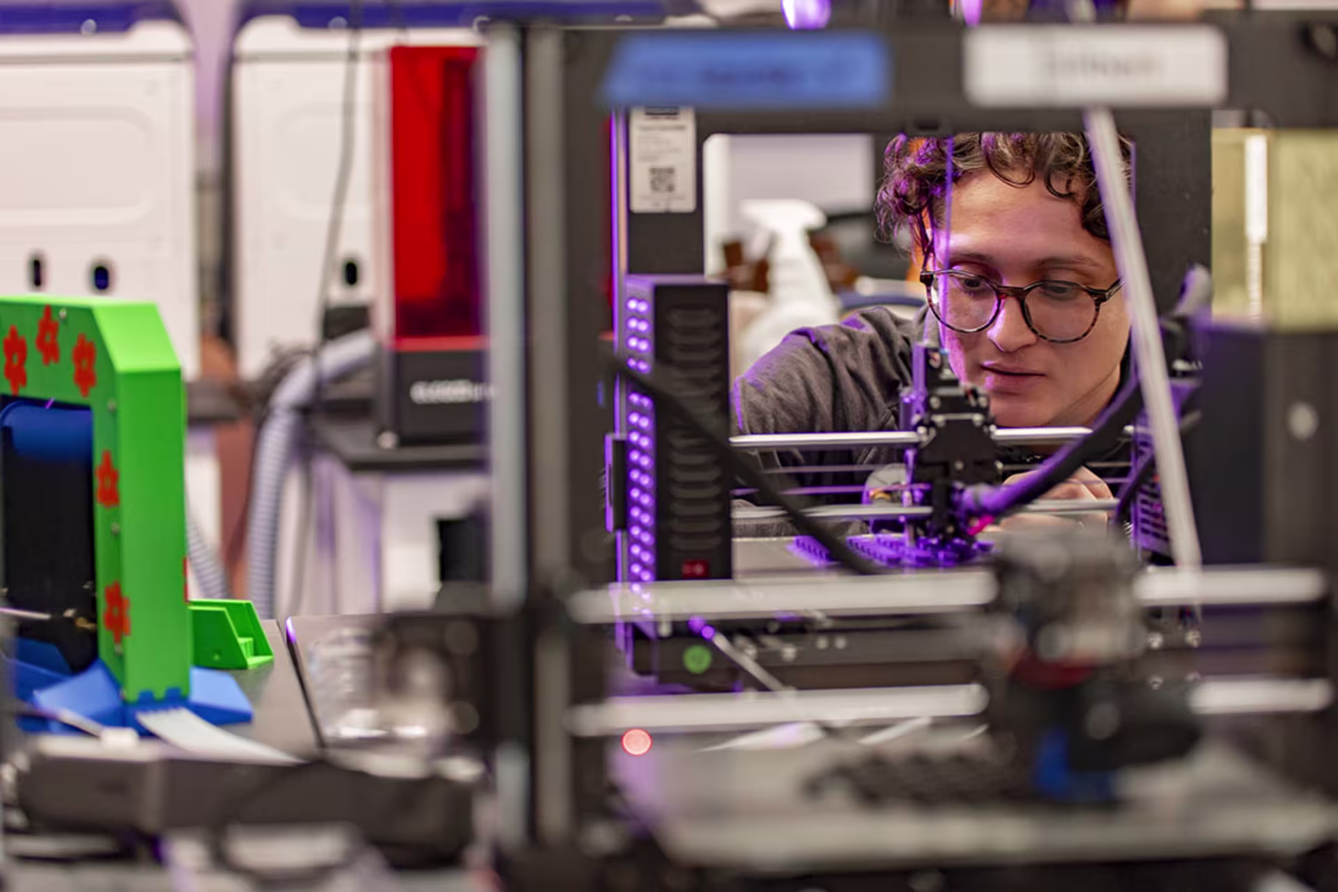 Male BS Mechanical Engineering technology student using 3D printer