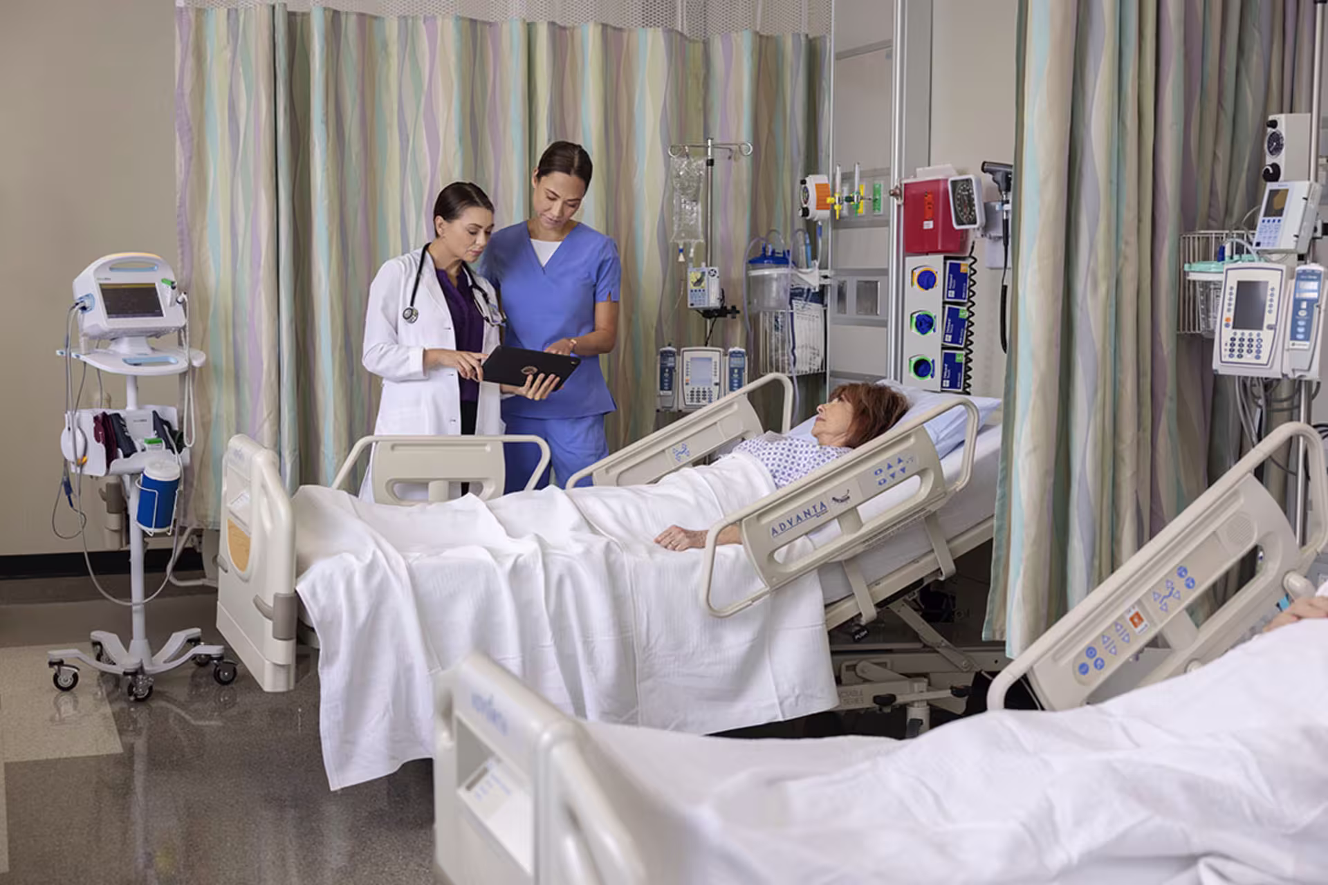 Female doctor and female nurse discussing results with female patient in hospital
