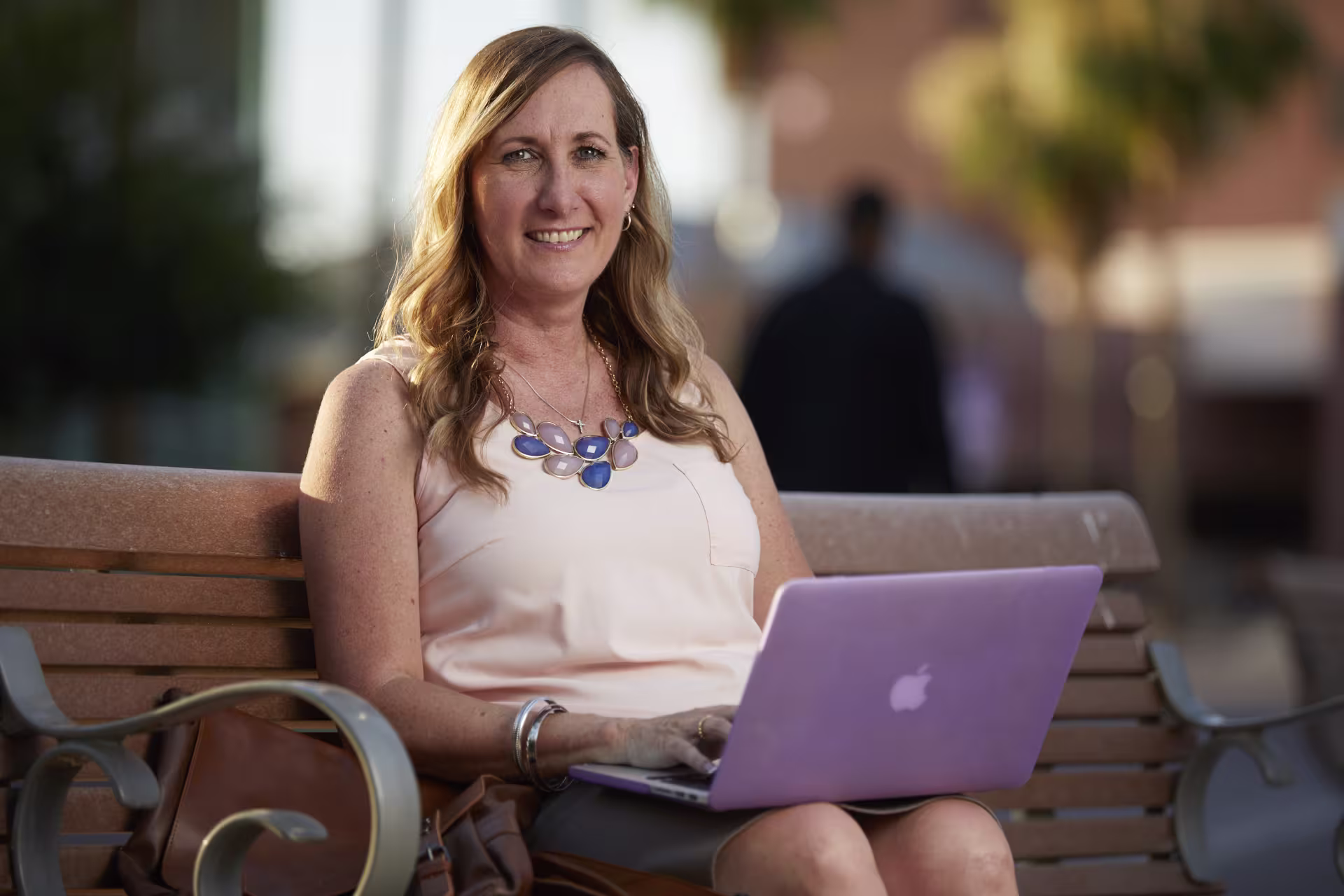 woman sitting on bench with laptop
