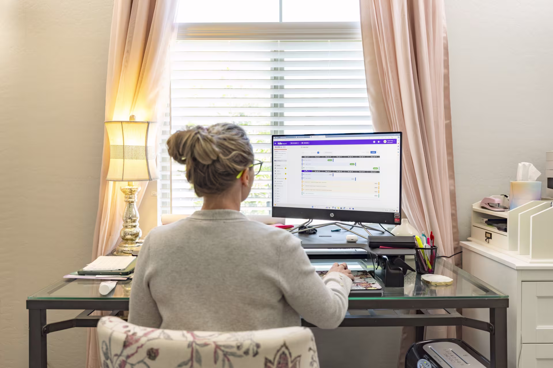Woman sitting at desk in home office while earning MSN FNP online