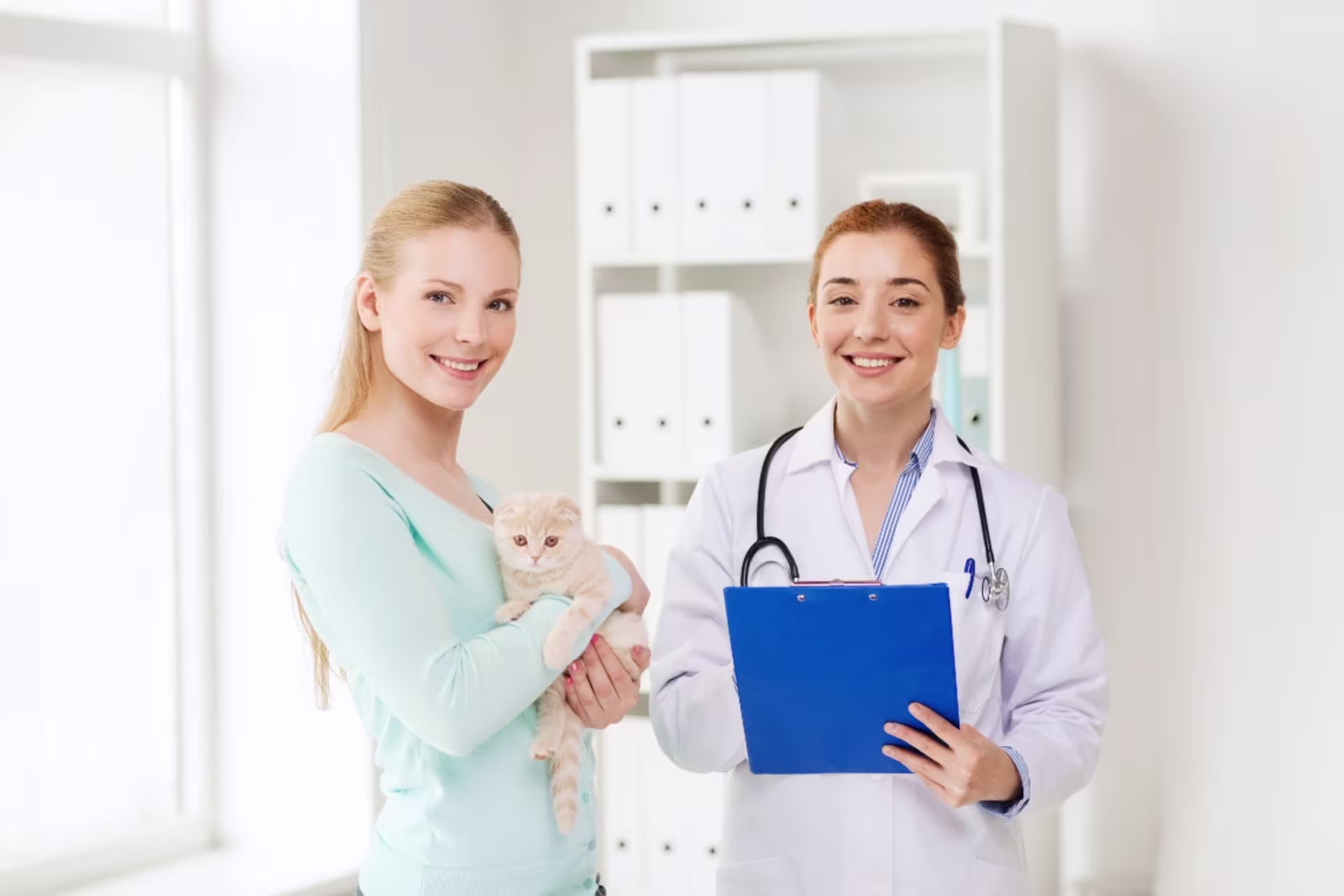 Pre-Vet student in clinic setting with woman who is holding a cat