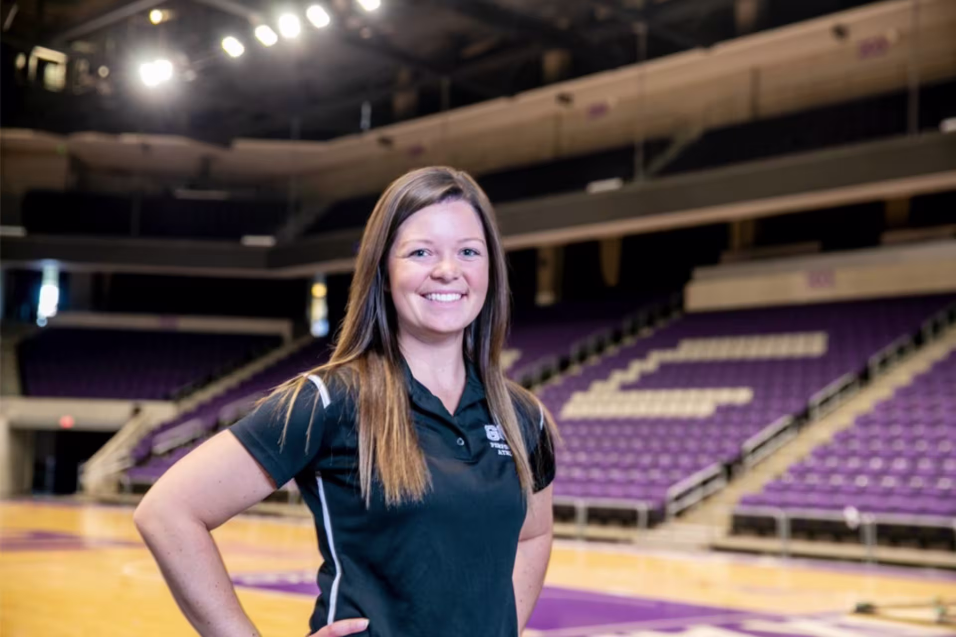 Athletic trainer standing in a gym with her hands on her hips