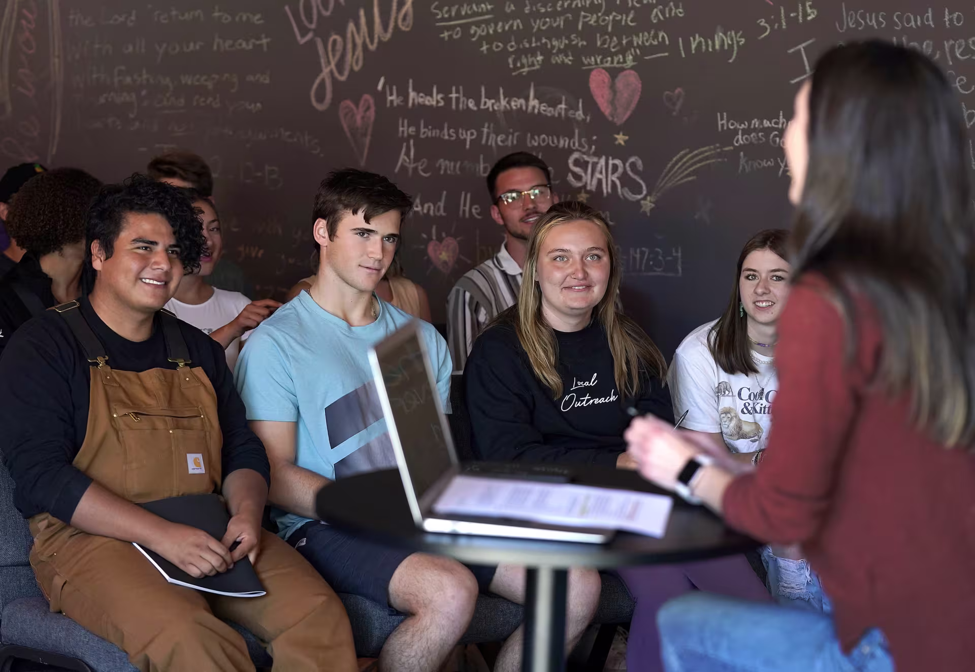 Female Christian leader using laptop while working with youth group