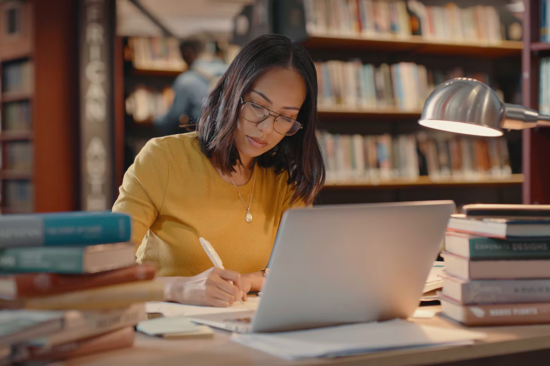 Female MA English with and emphasis in Education student studying on laptop in library