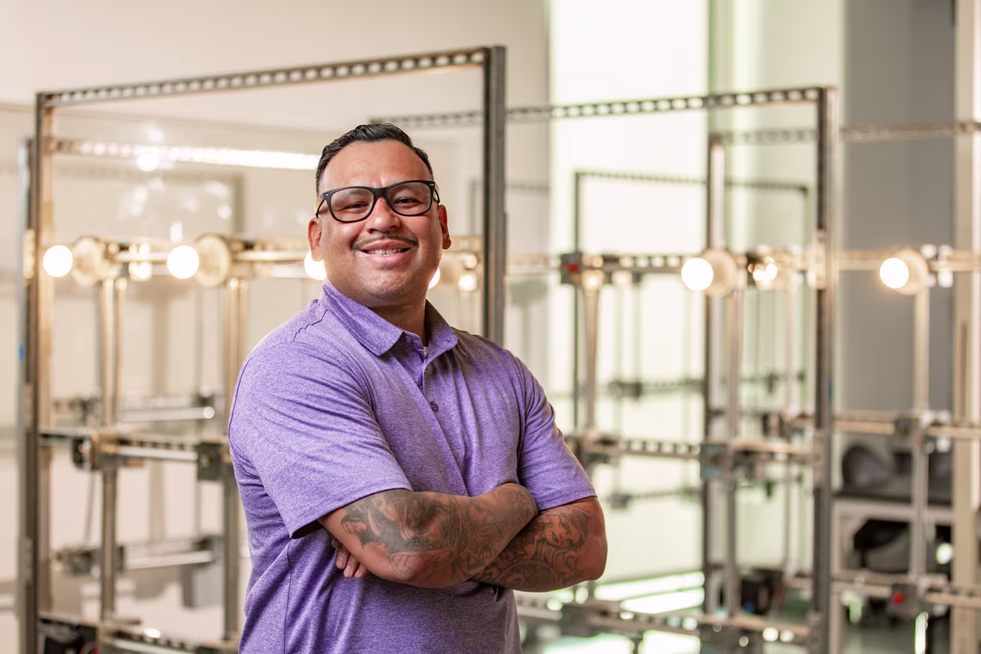 GCU student taking undergraduate certificate for electricians program standing in front of lighting structure
