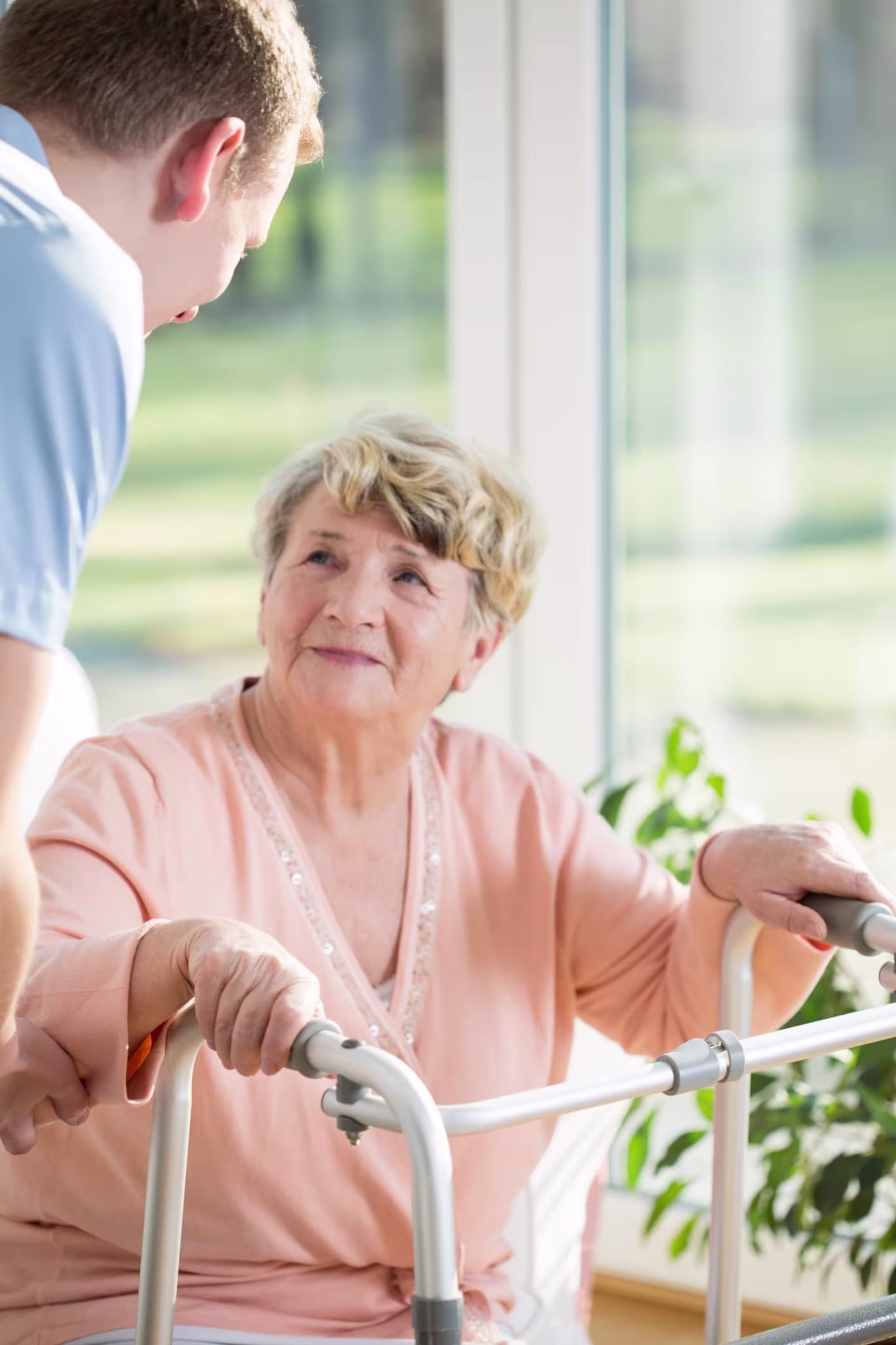 A geropsychology specialist speaks with an elderly woman in a comfortable setting.