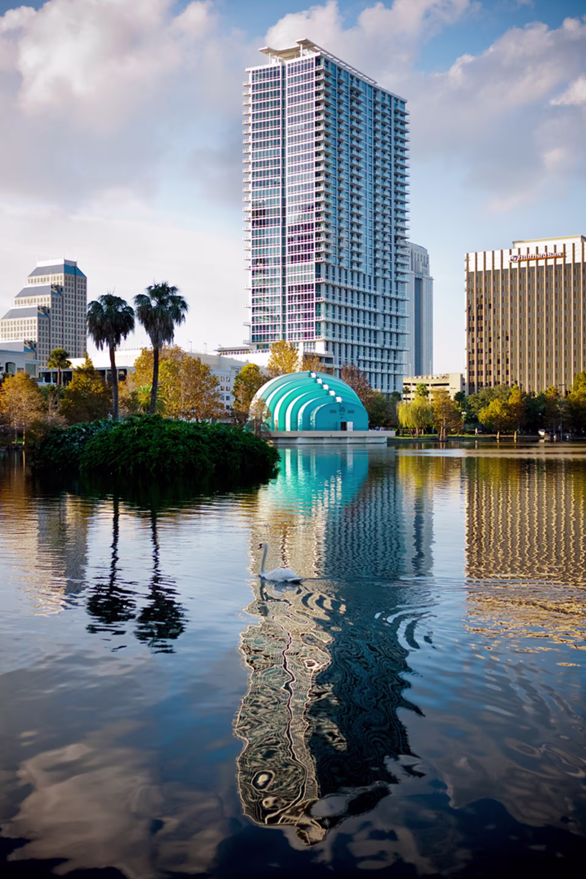 vertical view of lake eola in downtown orlando with tall buildings