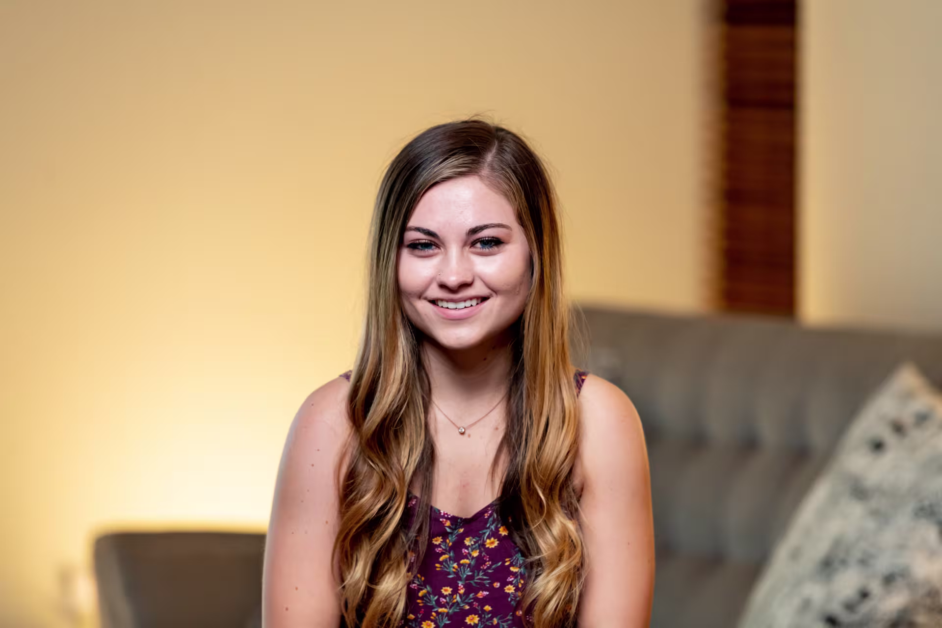 Female theology major smiling on couch in classroom