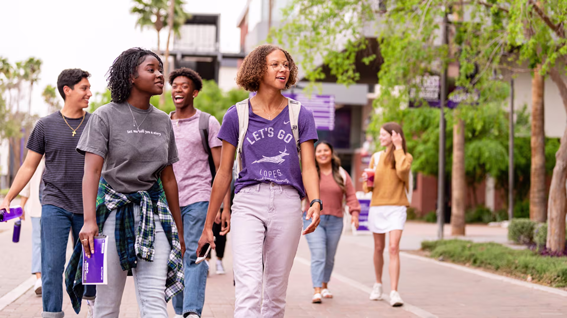 interracial group of gcu students walking down campus promenade