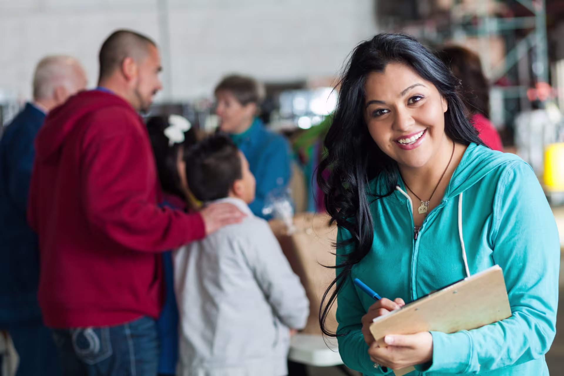 Sociologist smiles at the camera in blue hoodie