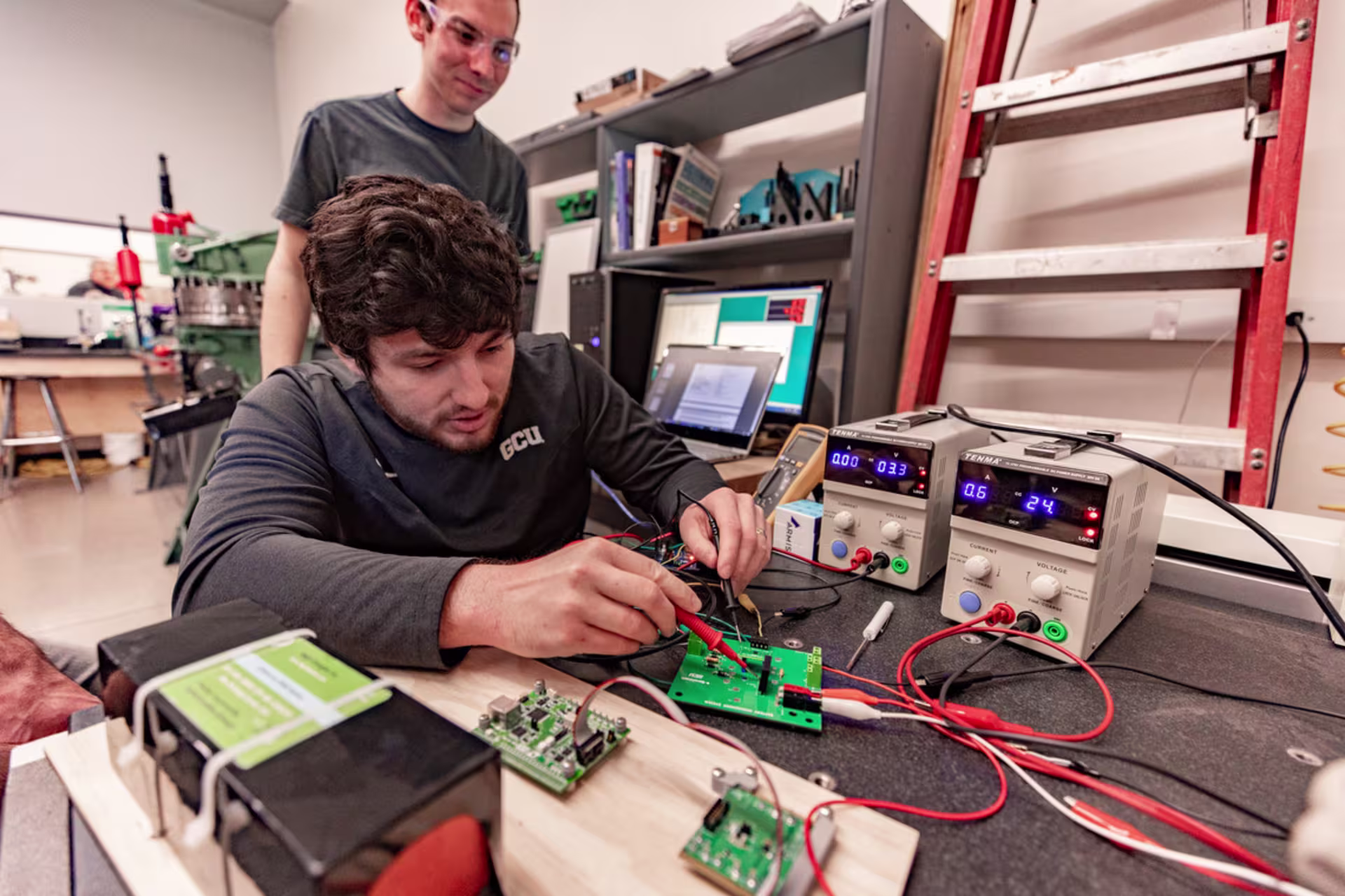 guy overlooks male student in gray shirt running electrical strength test