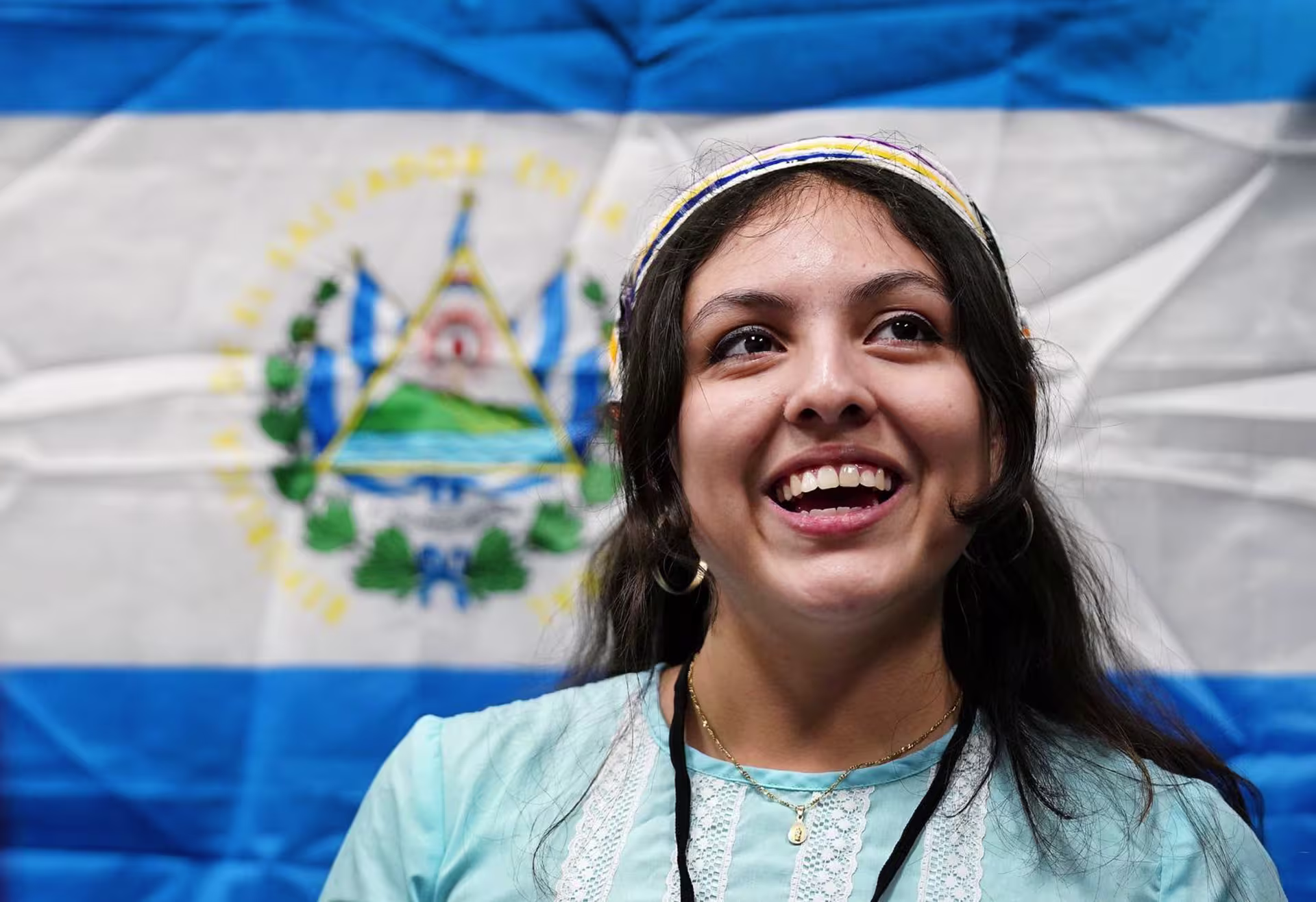 Headshot of female international student smiling in front of flag.