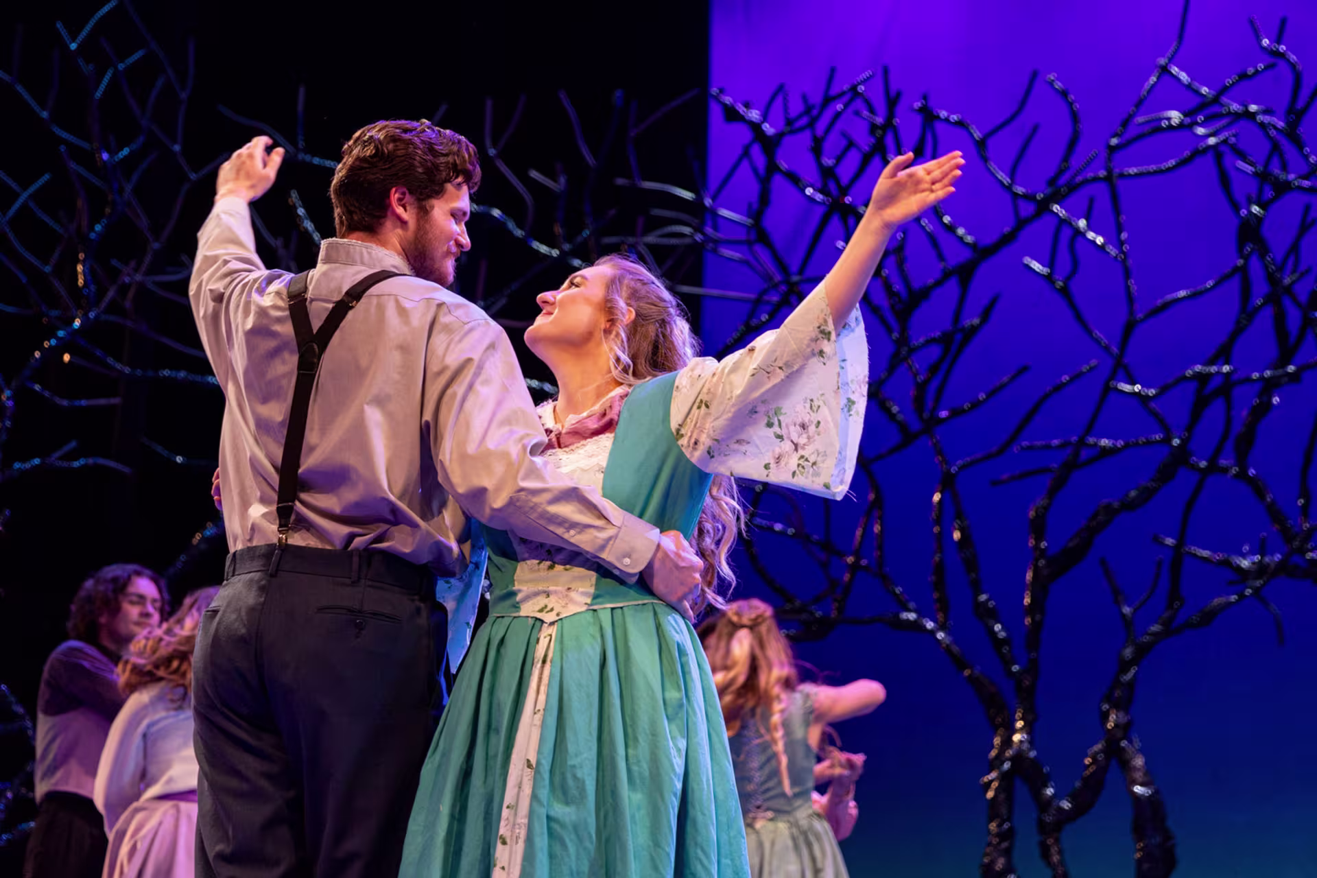 Male and female theatre majors dancing in costumes on stage during performance