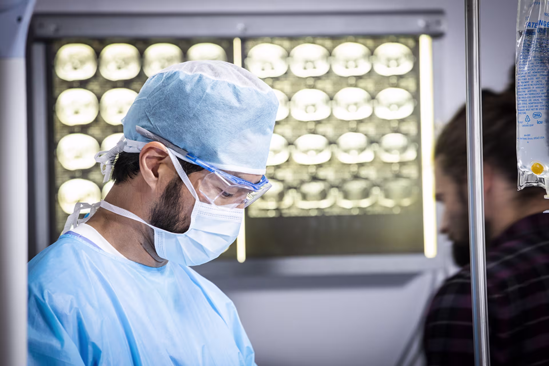 Male doctor looking down with brain x-rays behind him