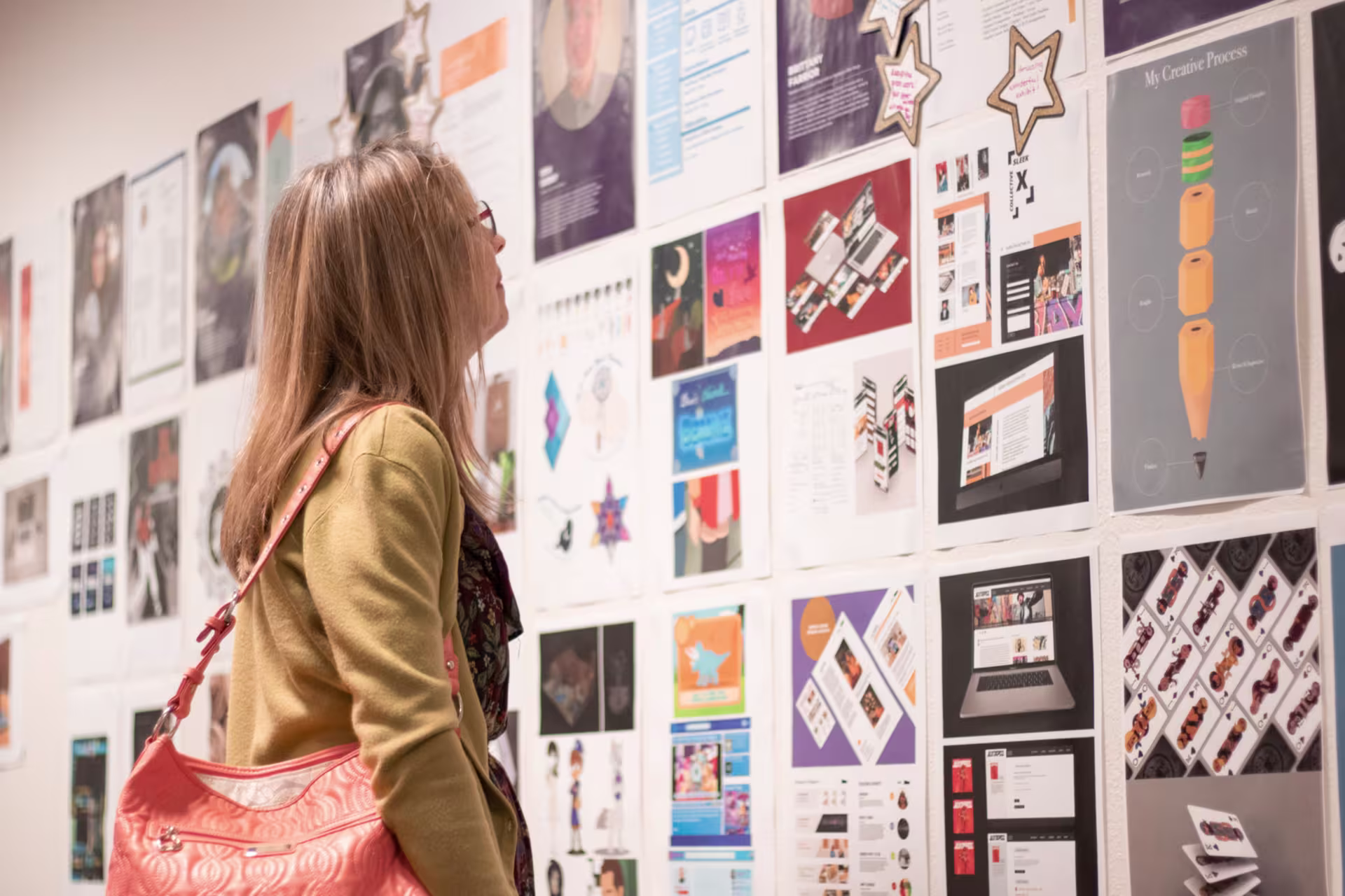 Woman looking at examples of digital design creative on wall