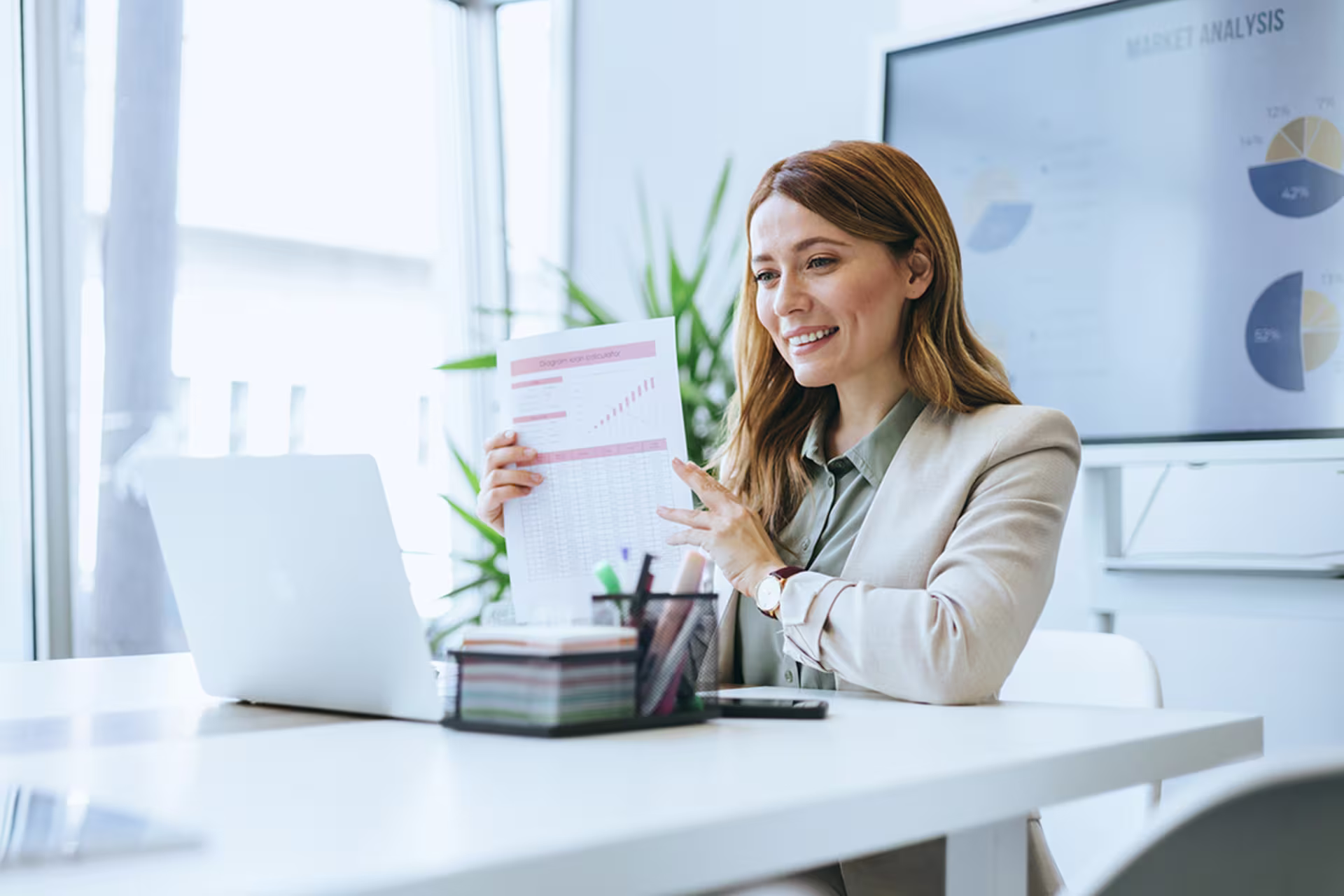 Brunette female accountant giving a presentation to a laptop at work