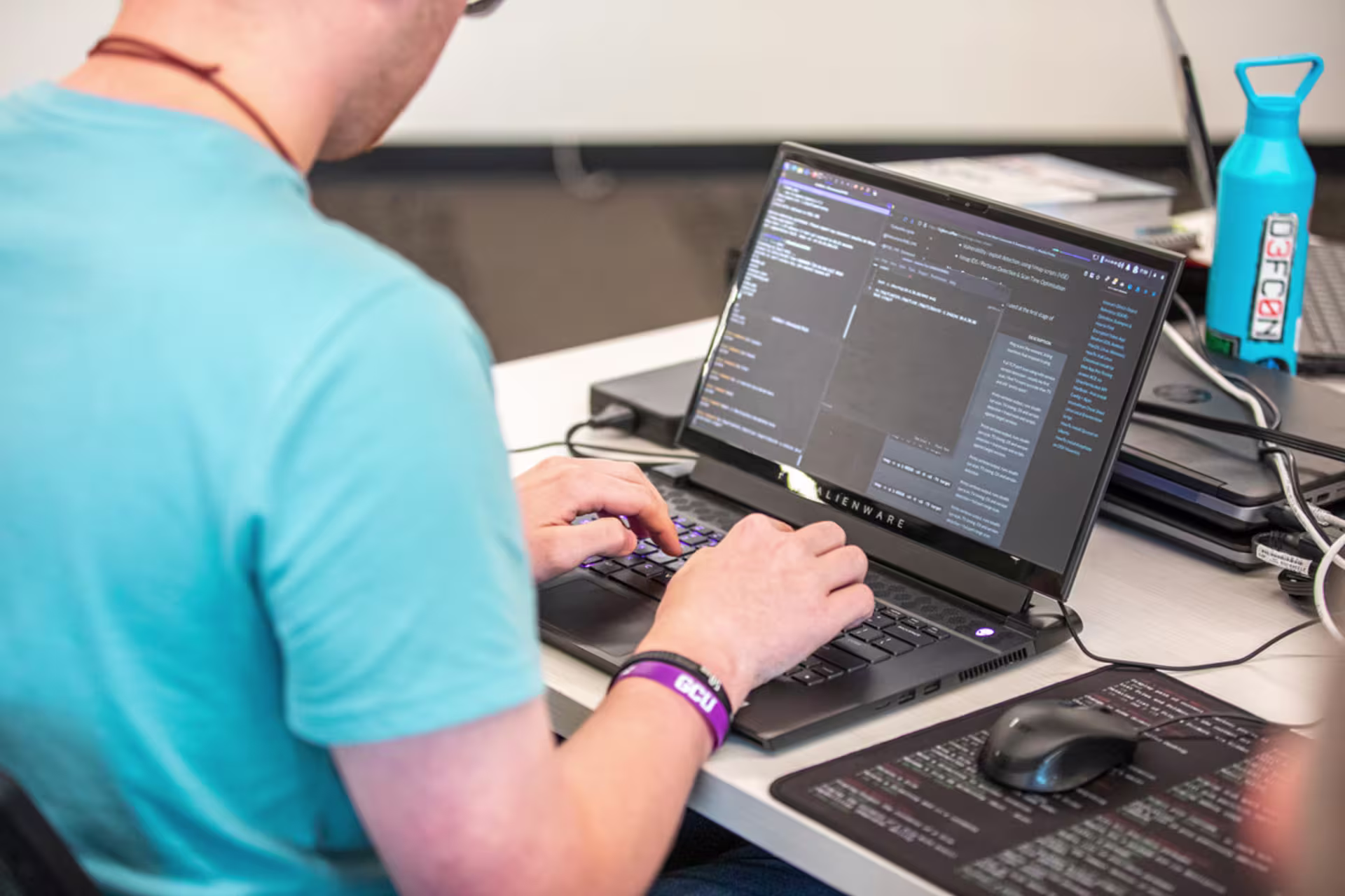 Software development student typing on a computer in a lab setting