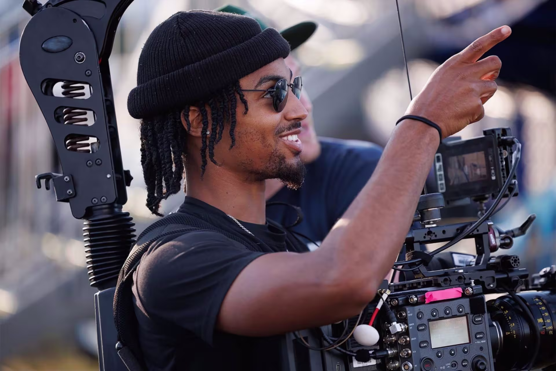 Media professional standing in hat with film equipment