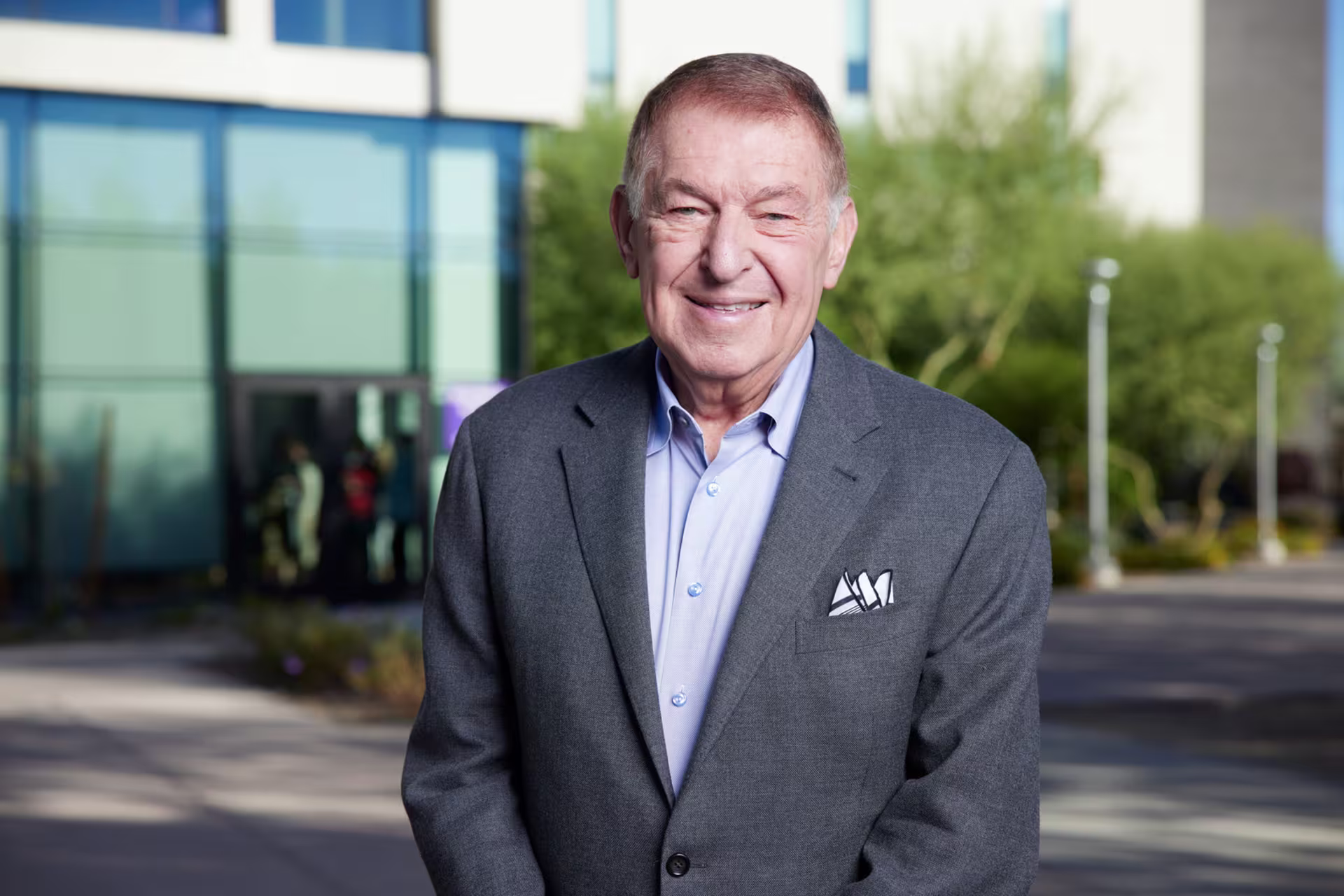Headshot of Jerry Colangelo in front of building and trees on college campus.